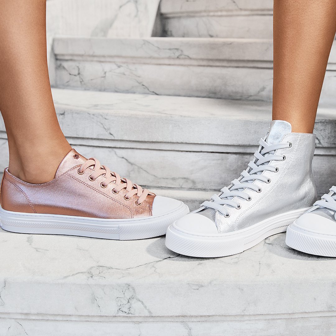 metallic sneakers in pink and silver standing on marble steps