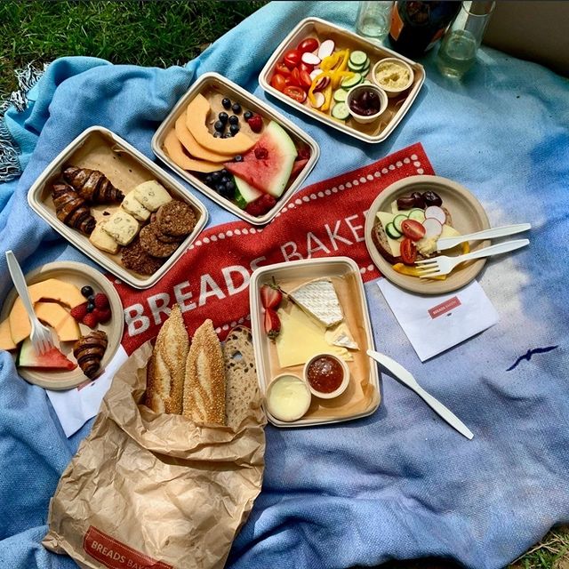 picnic with breads bakery items on a breads bakery branded blanket