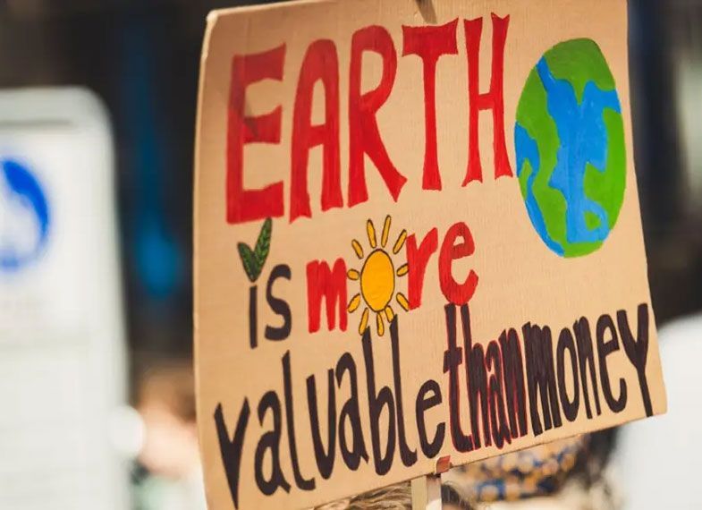 A poster which reads "Earth is more valuable than money"