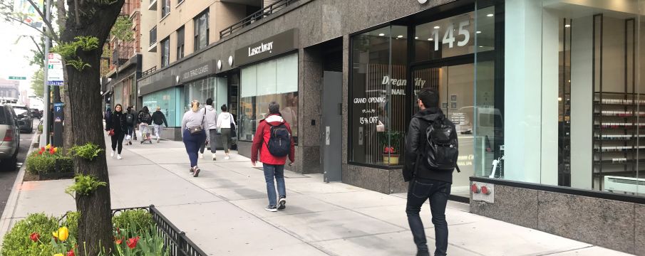 pedestrians walk along Amsterdam Ave in the spring