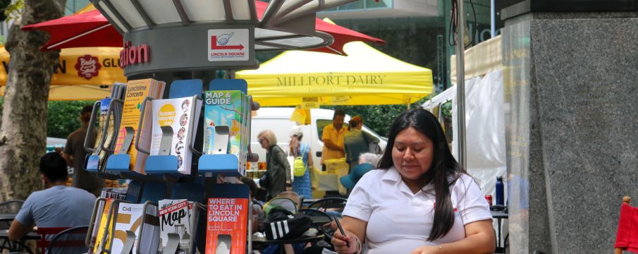 An Information Ambassador  takes notes at an Information Cart in Richard Tucker Park