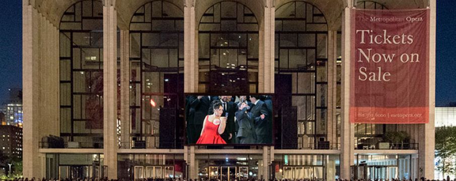 a crowd of people gathers on Lincoln Center_s plaza to watch a free screening