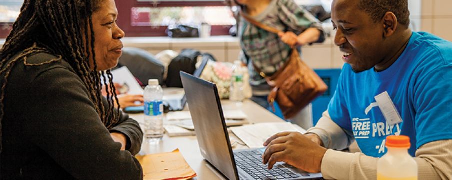 a Tax-Aide rep helps a woman complete her taxes inside of a library