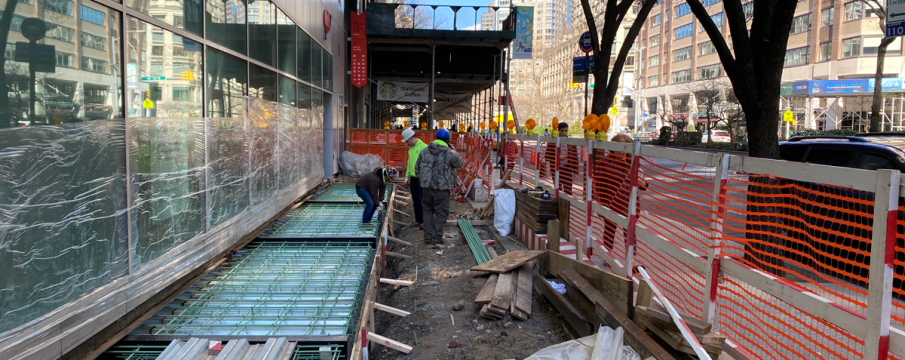 construction workers doing repair work on the sidewalk in front of the AAA building on Broadway