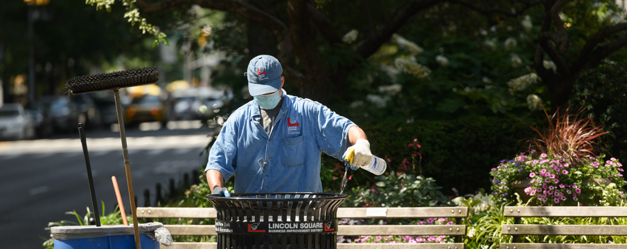 a clean team member cleans the edge of an LSBID branded trash can