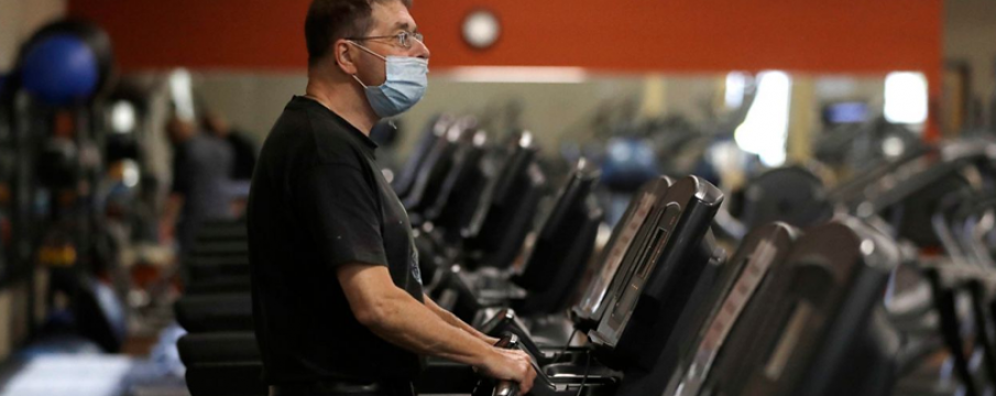 man wearing a mask on a treadmill in a gym