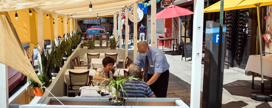 a waiter serving diners outside