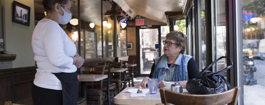 diner and waiter interacting inside a restaurant during the covid19 pandemic