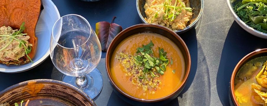 Thanksgiving dishes from Le Botaniste set up on a blue tablecloth 