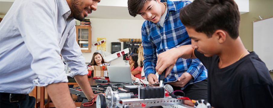 teacher helping kids with a STEM project