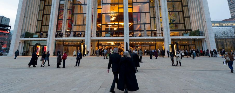 folks gather outside of the Met Opera in wintertime, headed to see a show