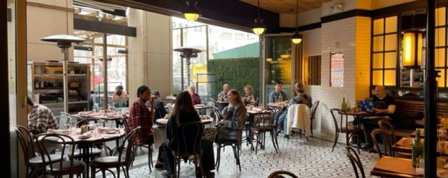 some partons dine inside at The Smith for breakfast by the front windows which have been opened for nice weather