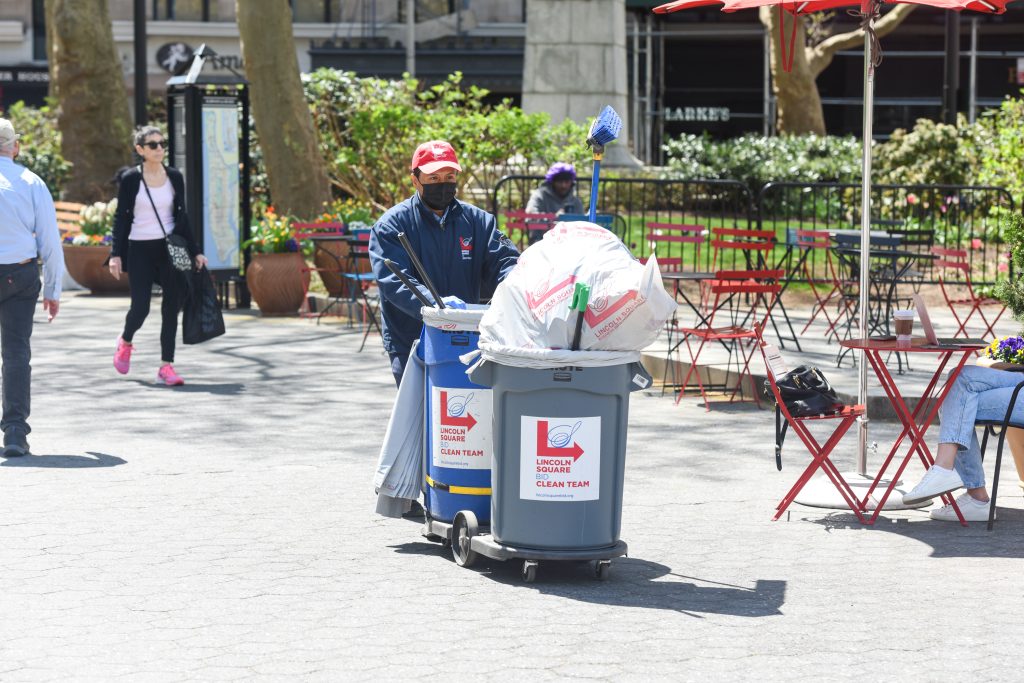 Photo of a Clean Team member pushing a cart of trash