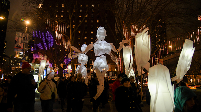 Photo of people carrying the Frost Giant puppets from Processional Arts Workshop